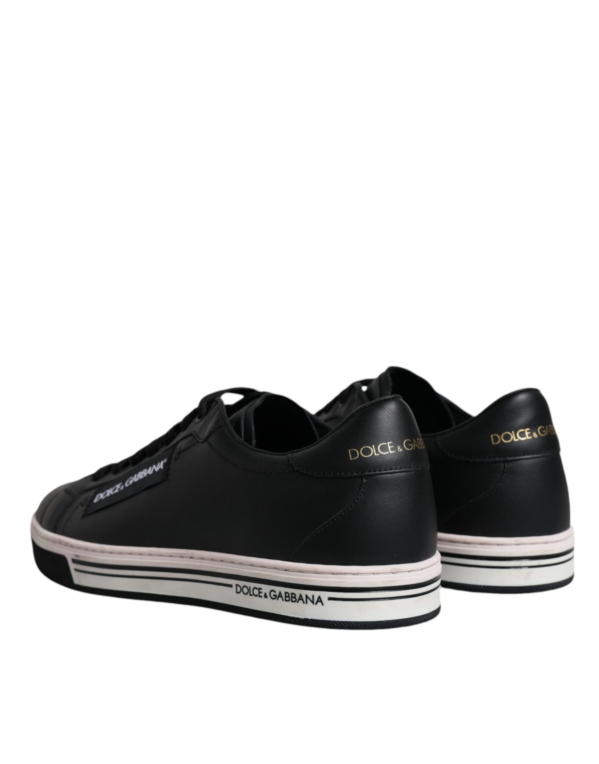 Pair of black sneakers with white soles and gold lettering on sides