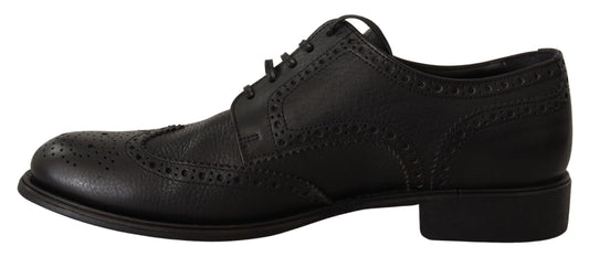 Black dress shoes with laces and embroidered details on top of each other