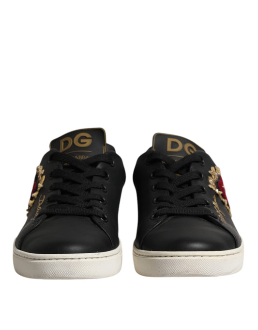 Pair of black leather sneakers with gold accents and a red heart on the side