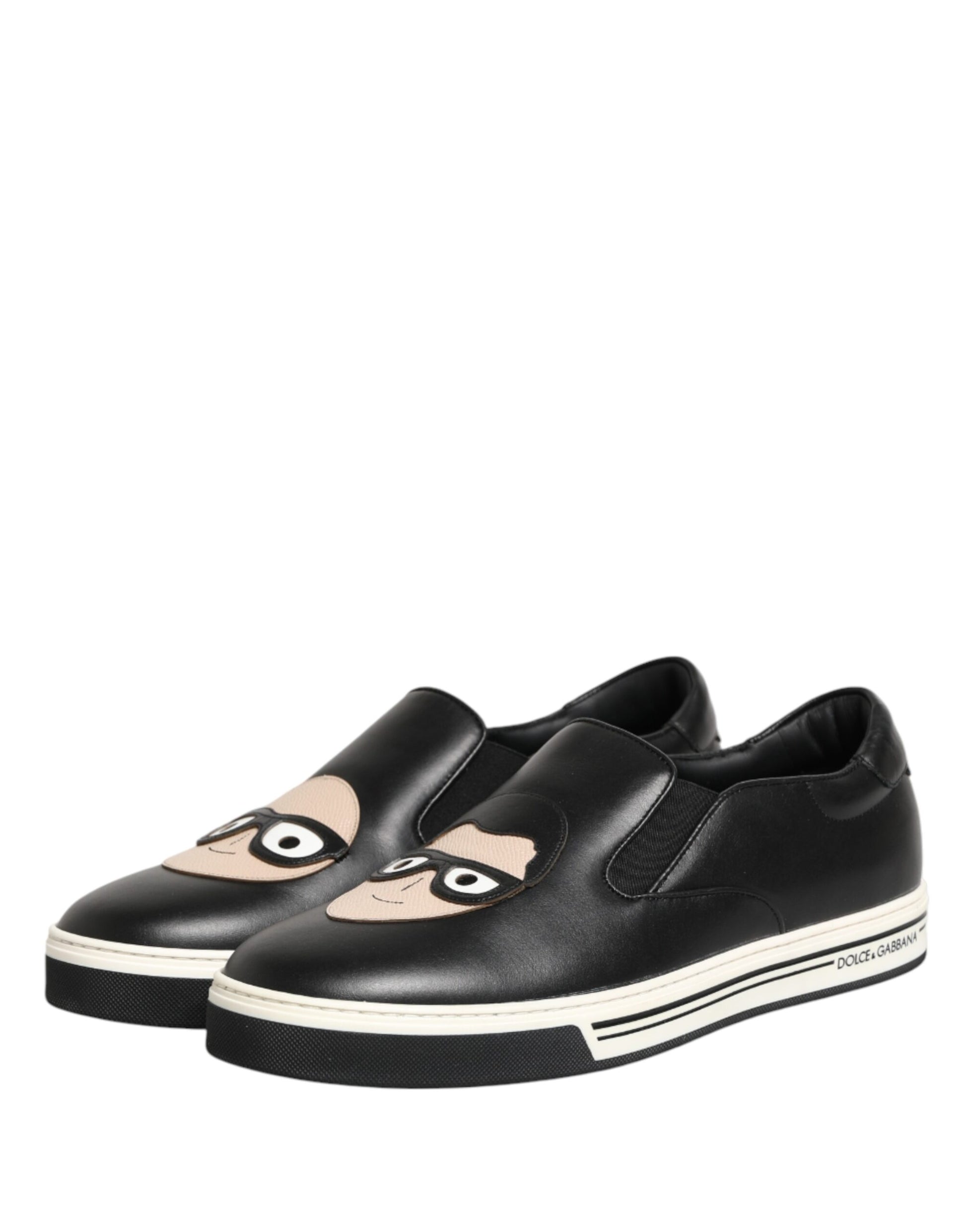 Pair of black shoes with white soles featuring cartoon faces on them