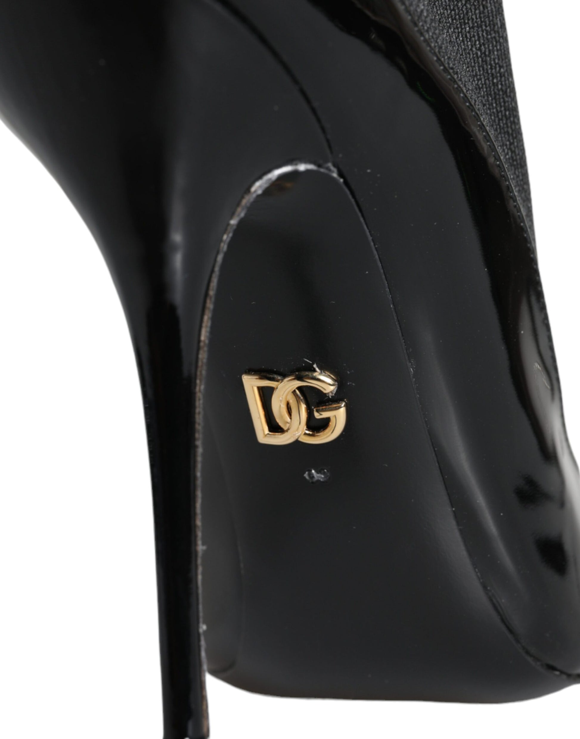 Black high heel shoe with gold logo on toe