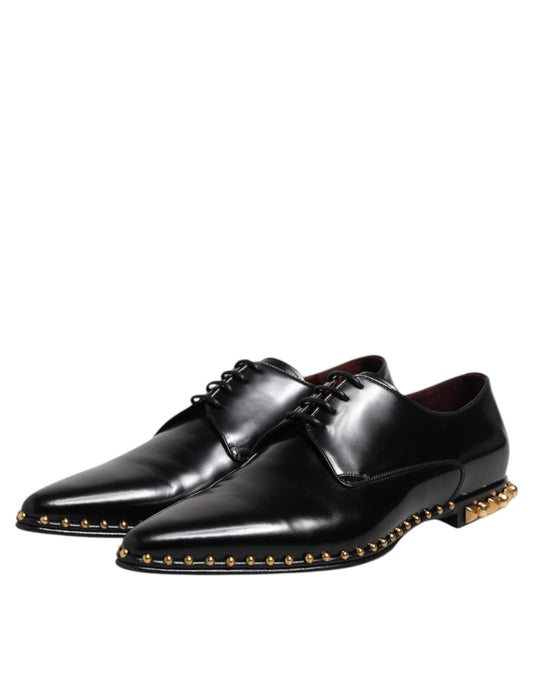 Pair of black leather shoes with gold studs, laces and heels
