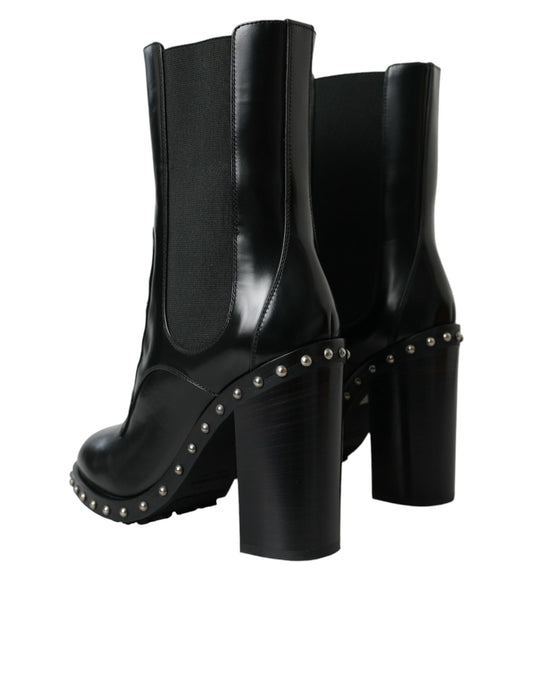 Pair of black knee high boots with studded details and a chunky heel
