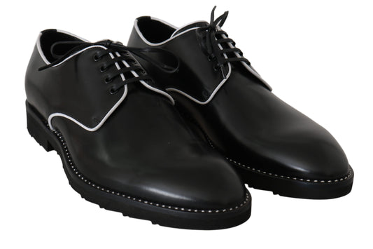 Pair of black dress shoes with laces and a small bow on each shoe