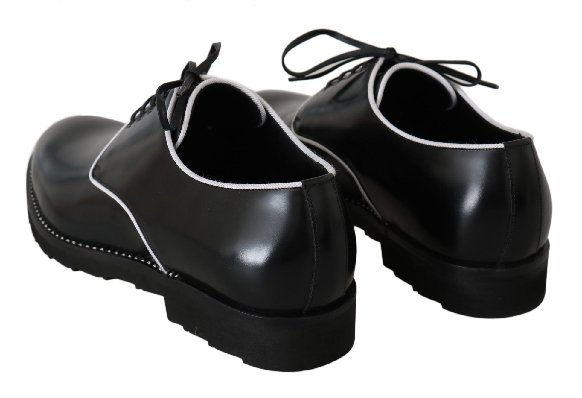 Pair of black dress shoes with laces and white trim around soles