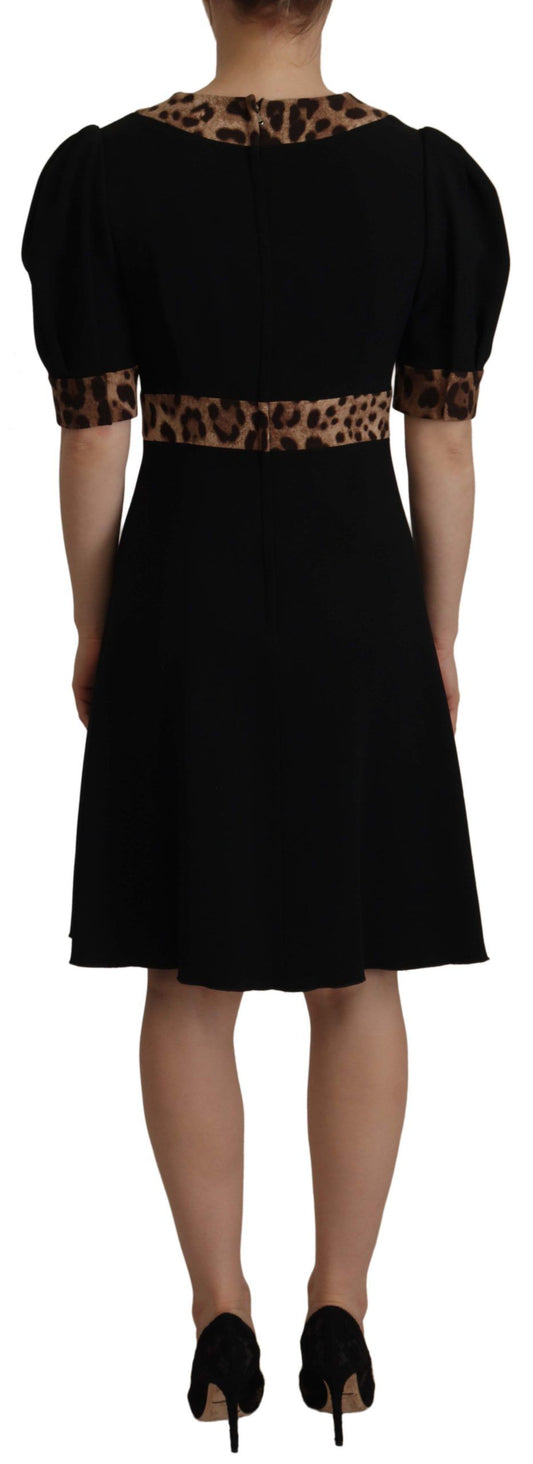 A black knee length dress with leopard print accents