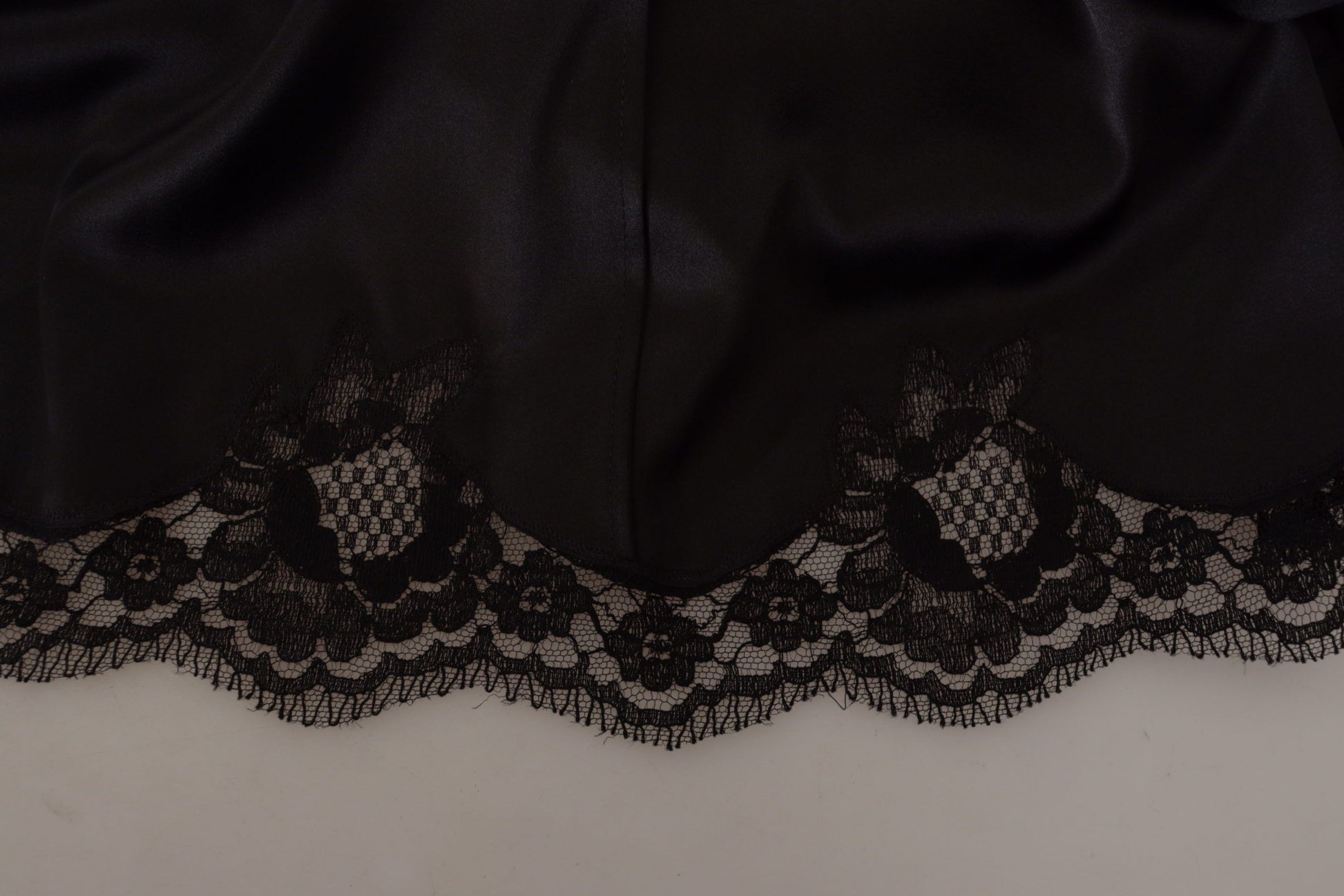 A black dress with lace detailing on the sleeves and hem. It is an A-line knee length dress from Dolce & Gabb