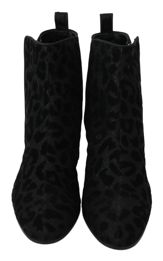 Pair of black knee high boots with animal print pattern