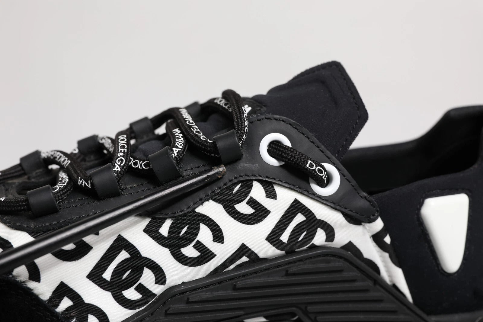 A pair of black lace-up sneakers with a logo pattern on the side