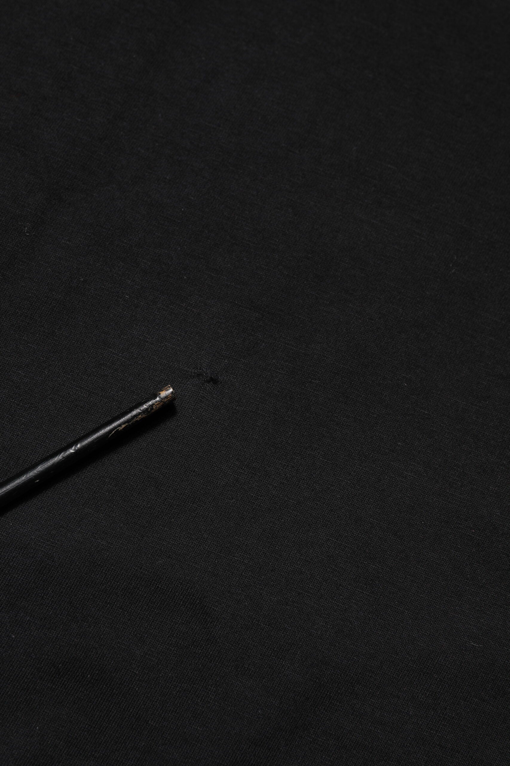 Small black needle on fabric
