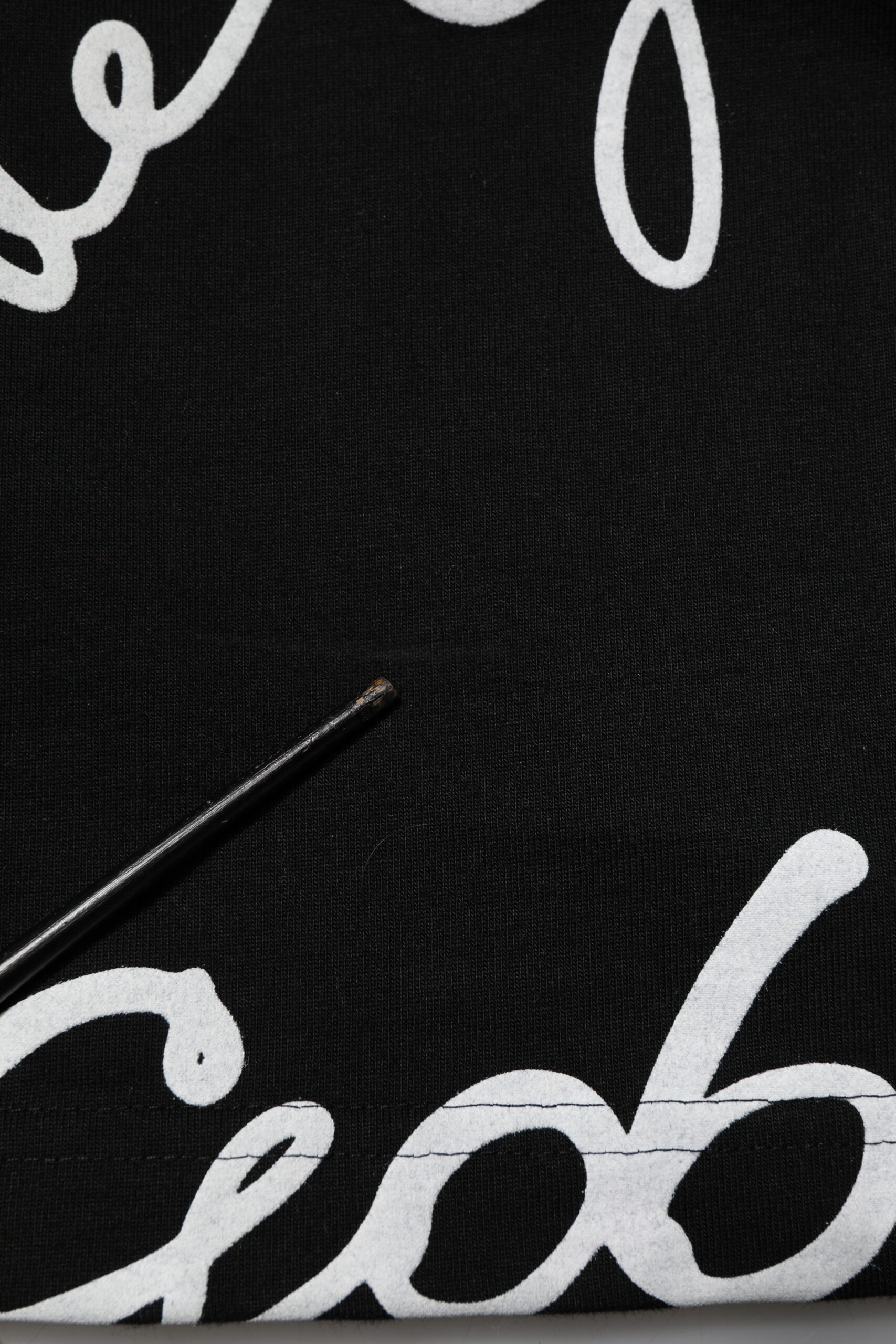 Black fabric with white embroidered letters