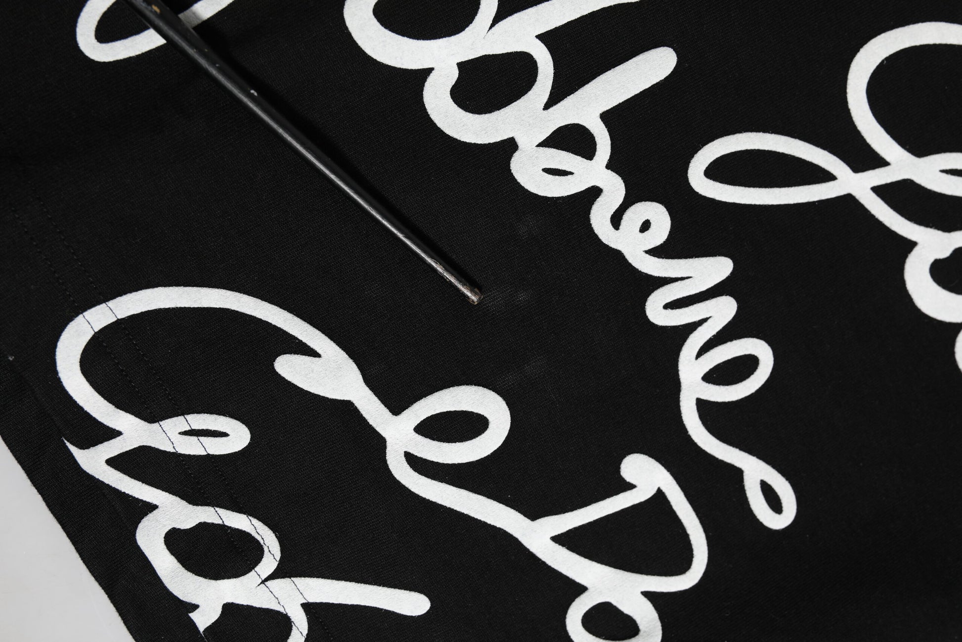 Hand embroidering white lettering on black fabric
