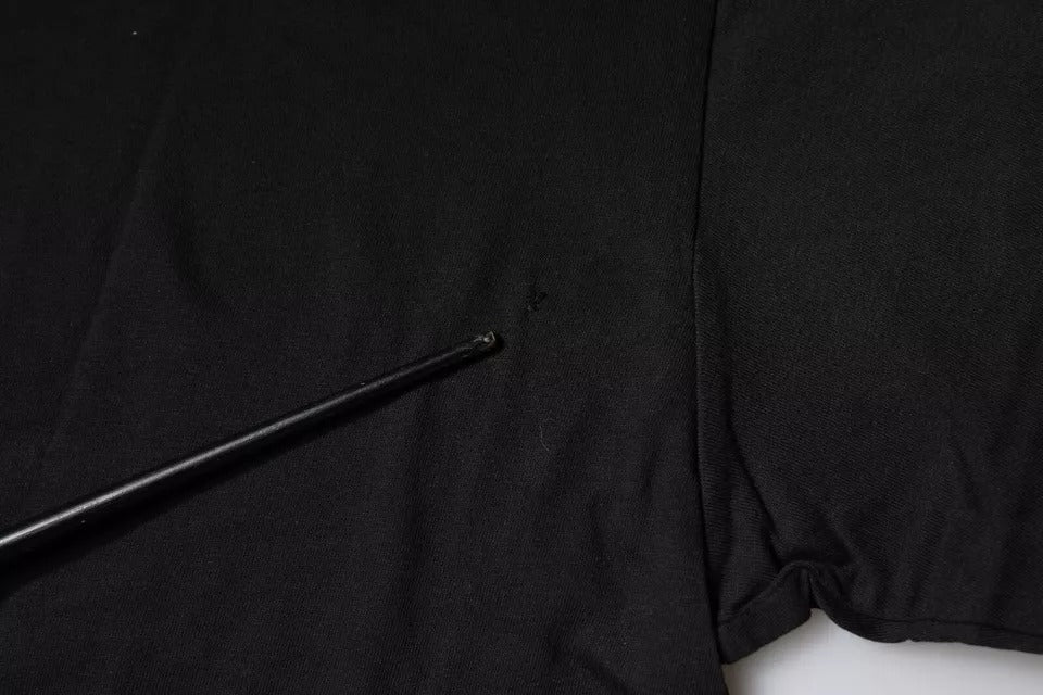 Black shirt on hanger with a black pole leaning against it