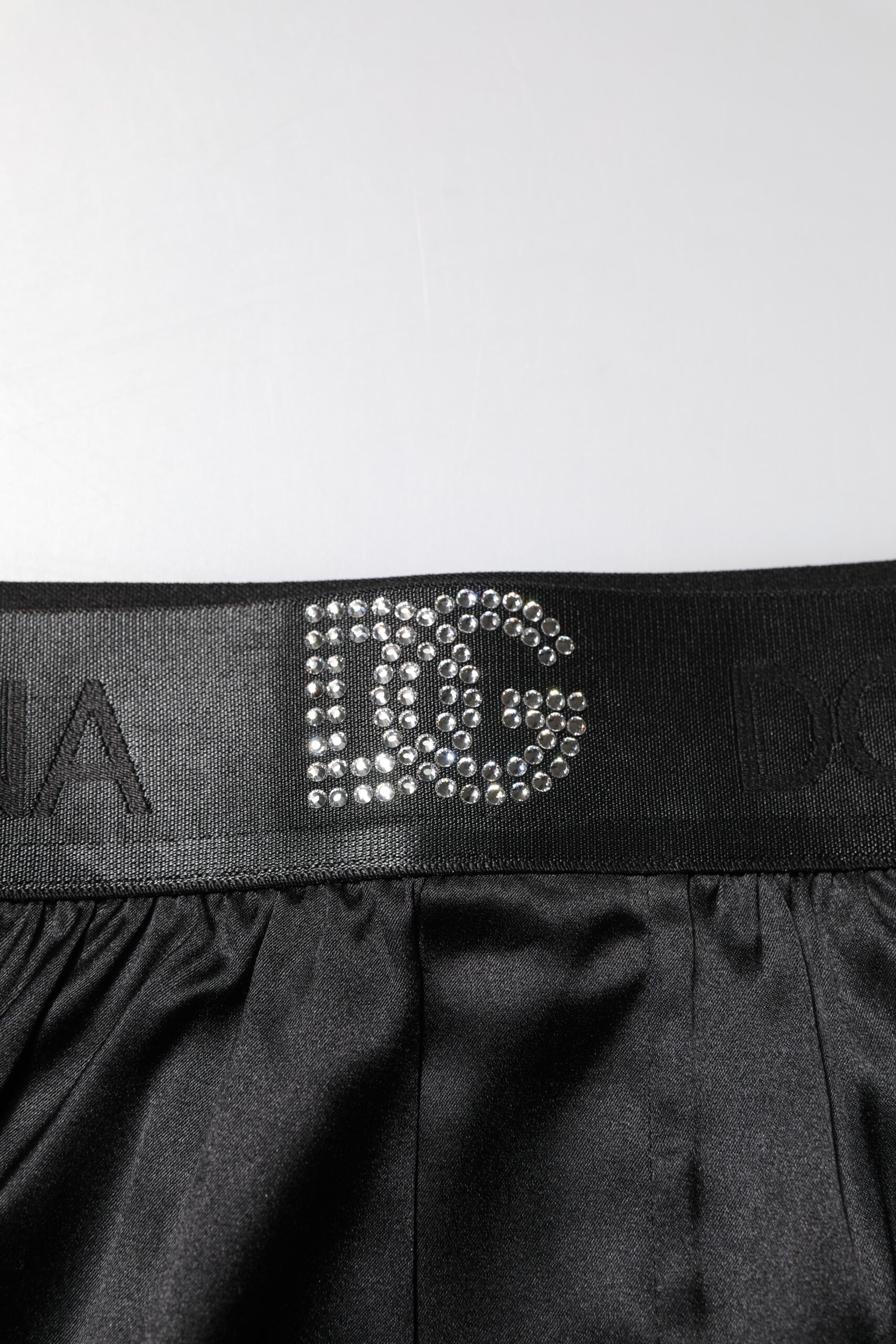 Black shorts with a silver logo on the waistband