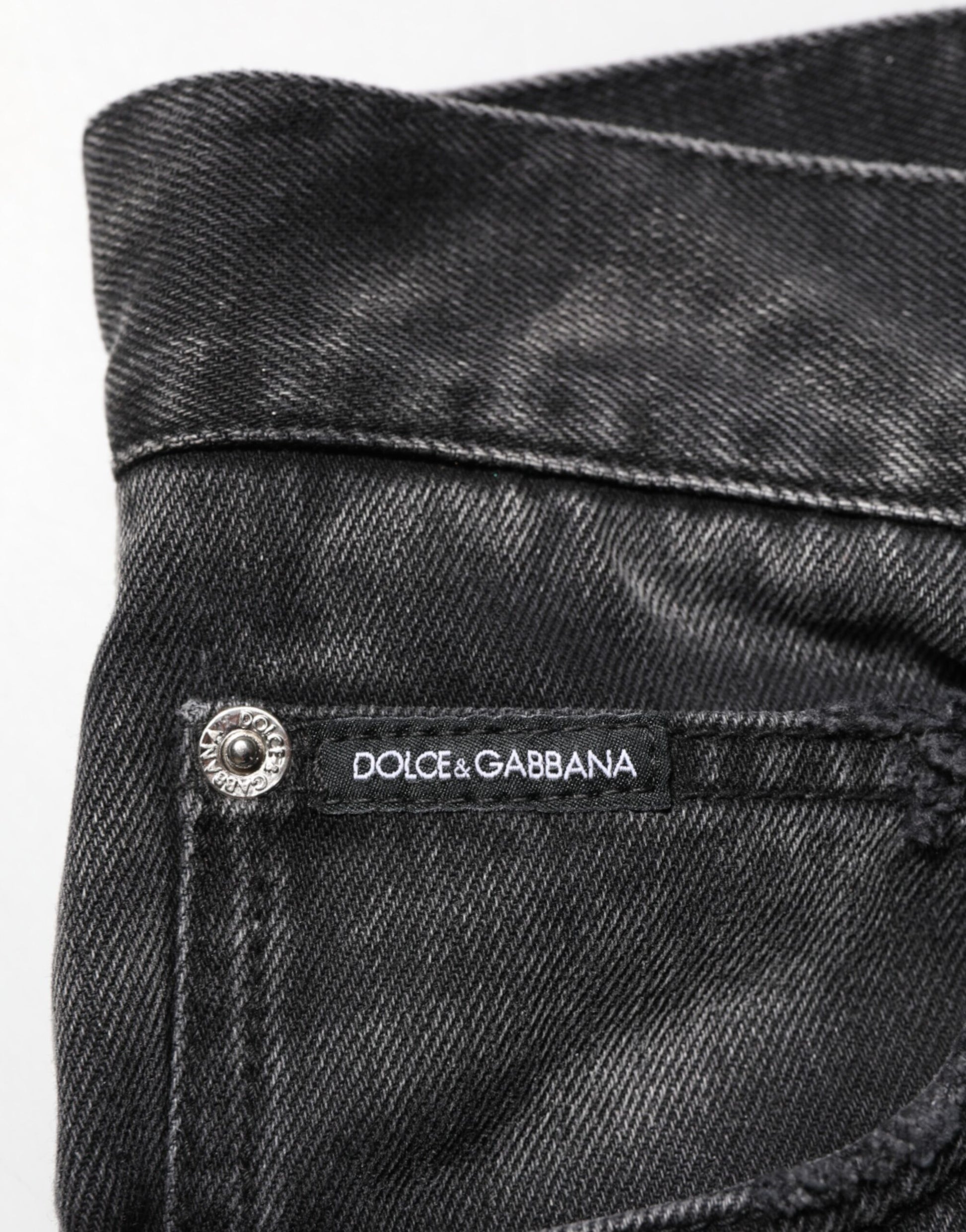 The jeans are black and have a label on the waistband that reads "Dolce & Gabbana"