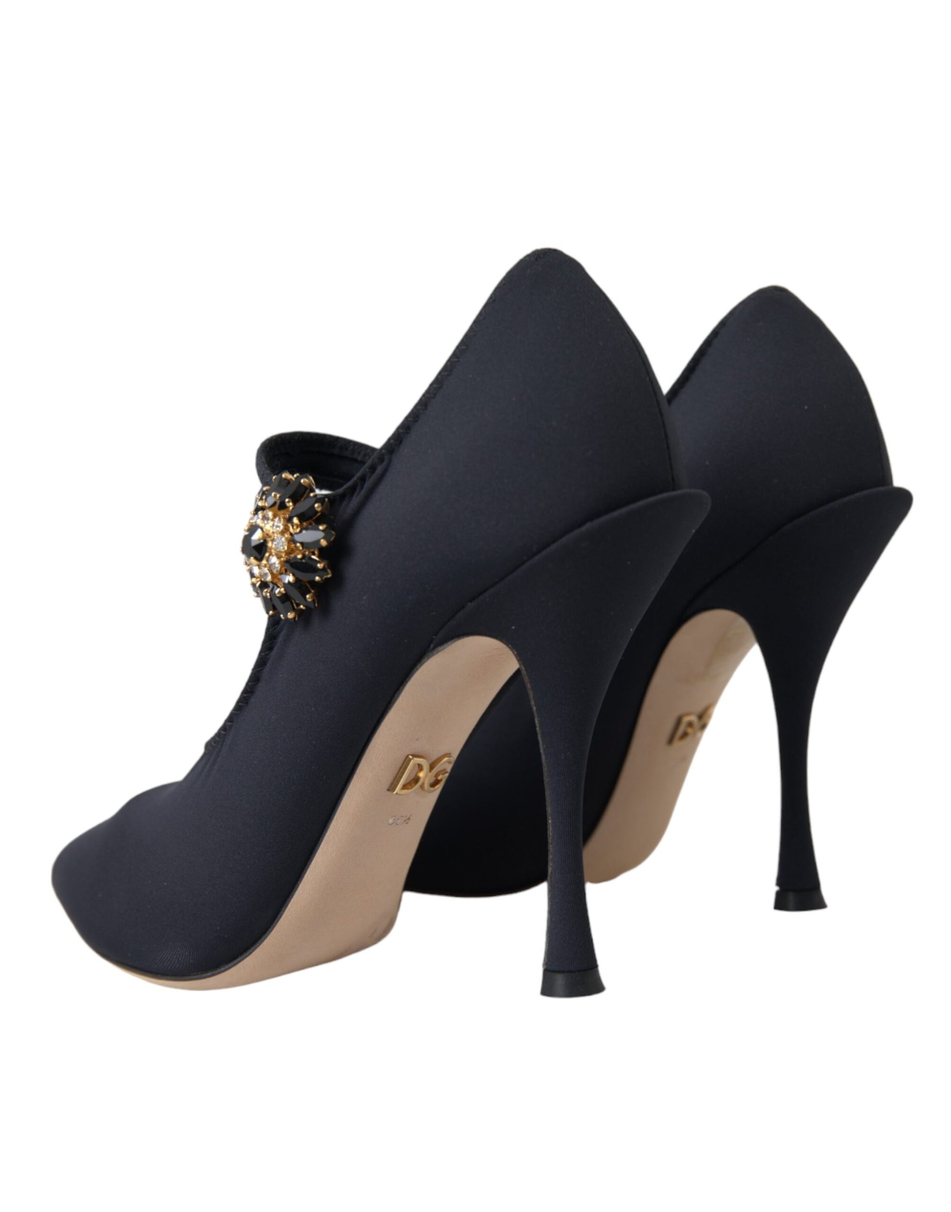 Pair of black high heel shoes with tan soles and a bow on top