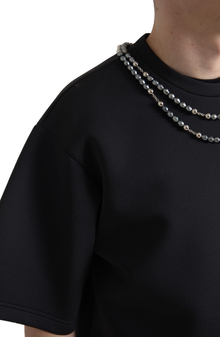 Man wearing black shirt with beaded necklace
