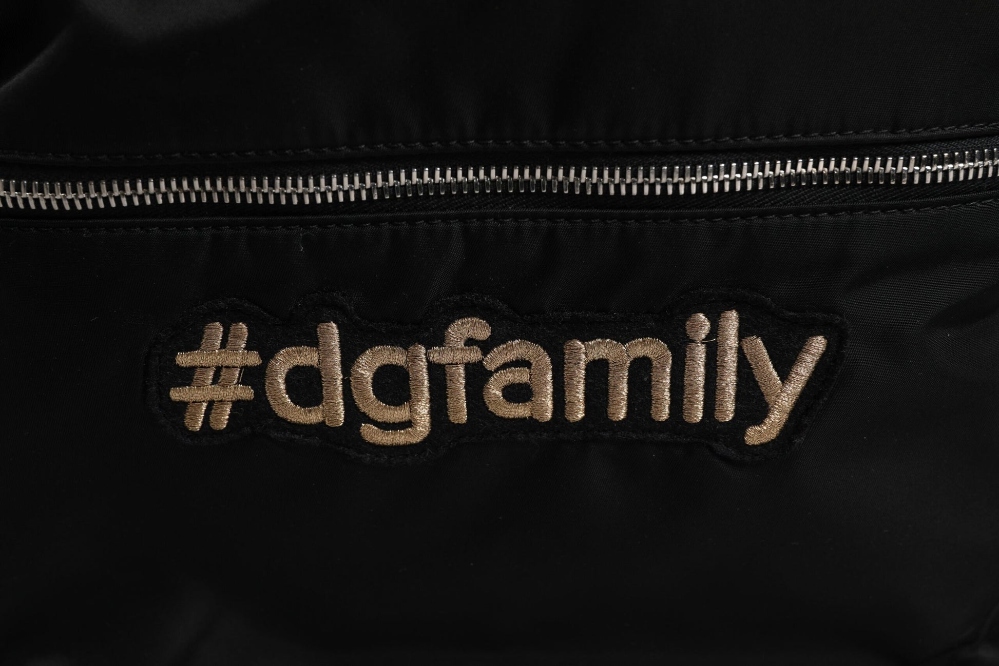 Black fabric with gold lettering reading #DGFAMILY