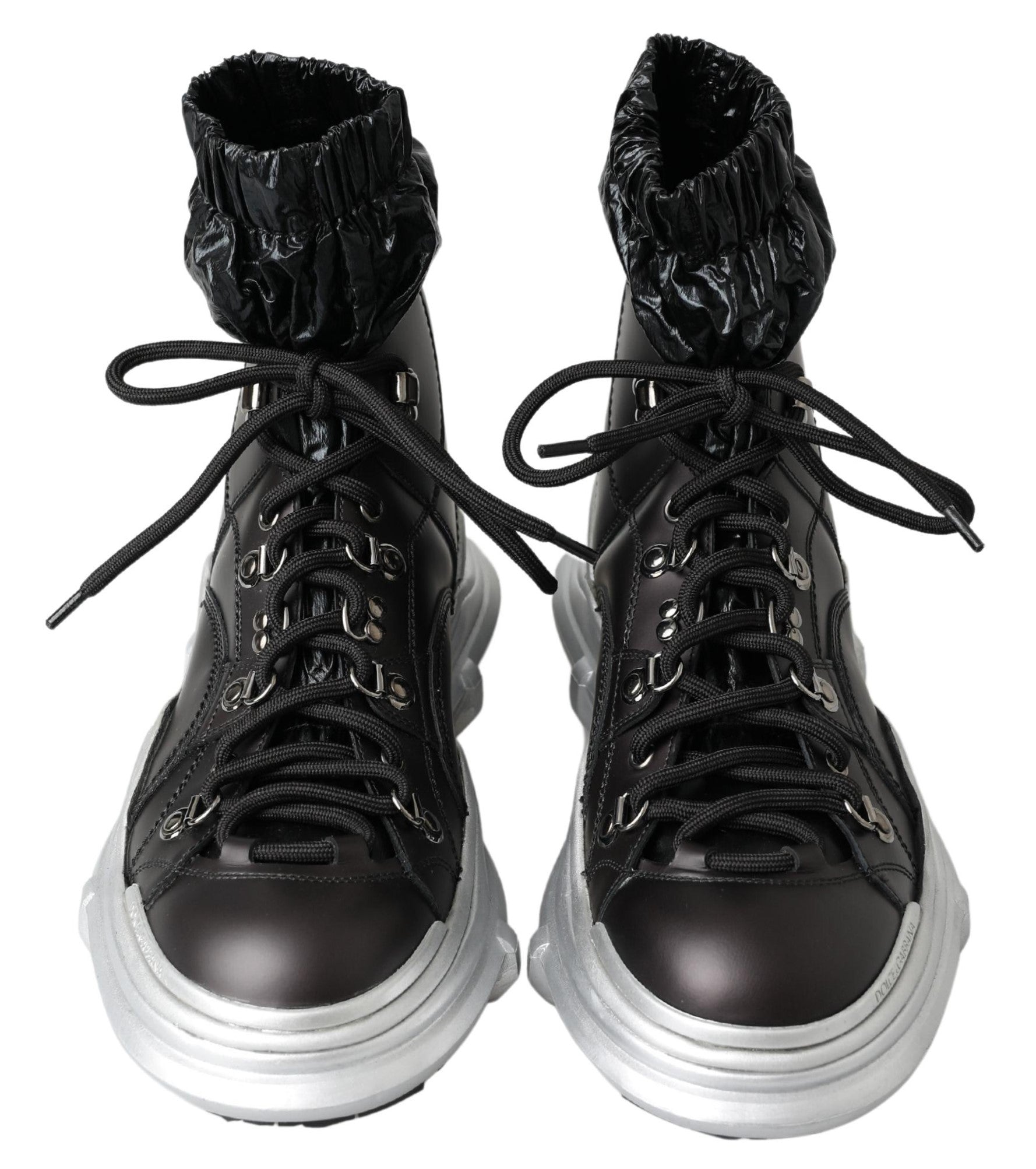 Pair of black boots with silver laces and a white sole