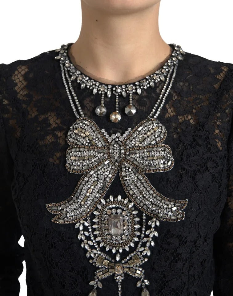 A black lace dress with a bow embellishment on the chest