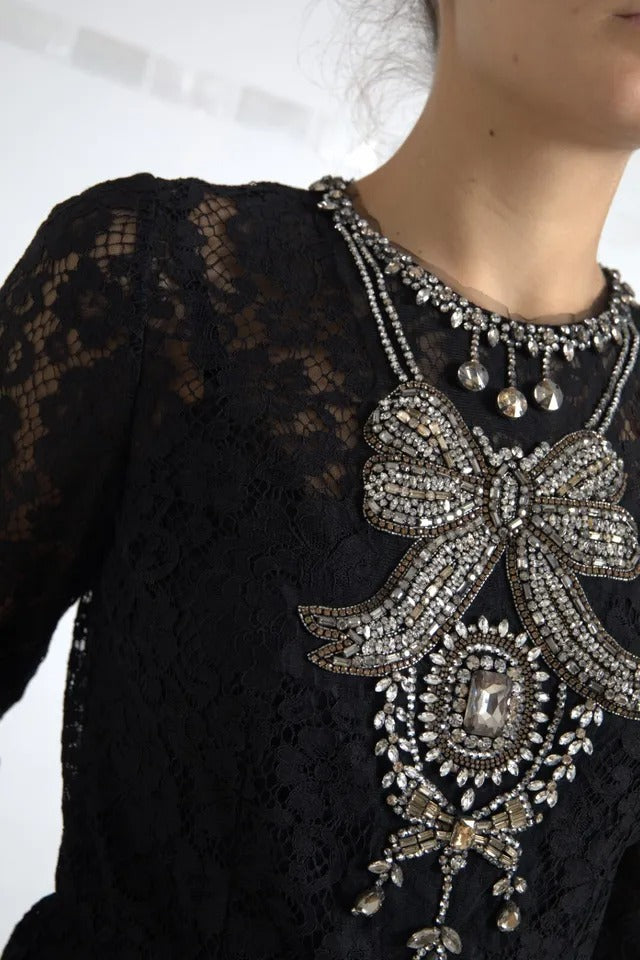 A black lace dress with a bow embellishment on the front