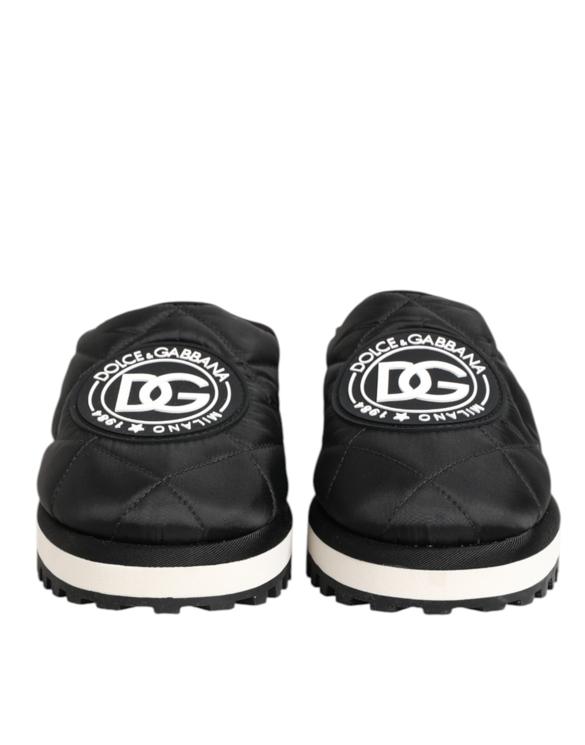 Pair of black nylon slip-on shoes with white soles, featuring a logo on the side