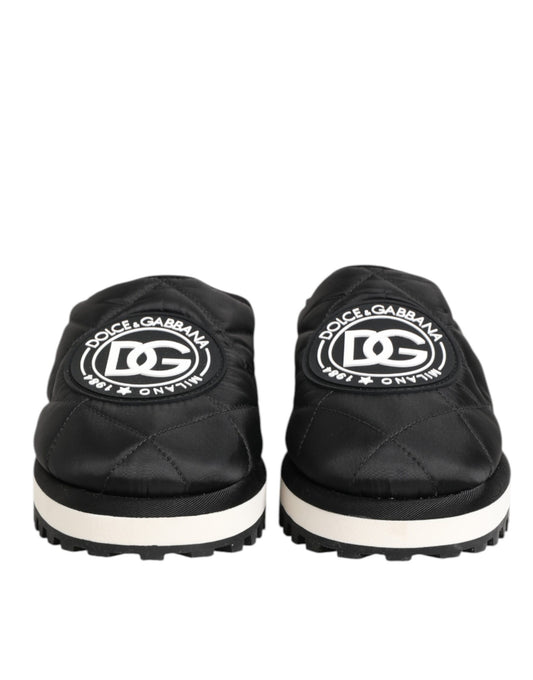 Pair of black nylon slip-on shoes with white soles, featuring a logo on the side