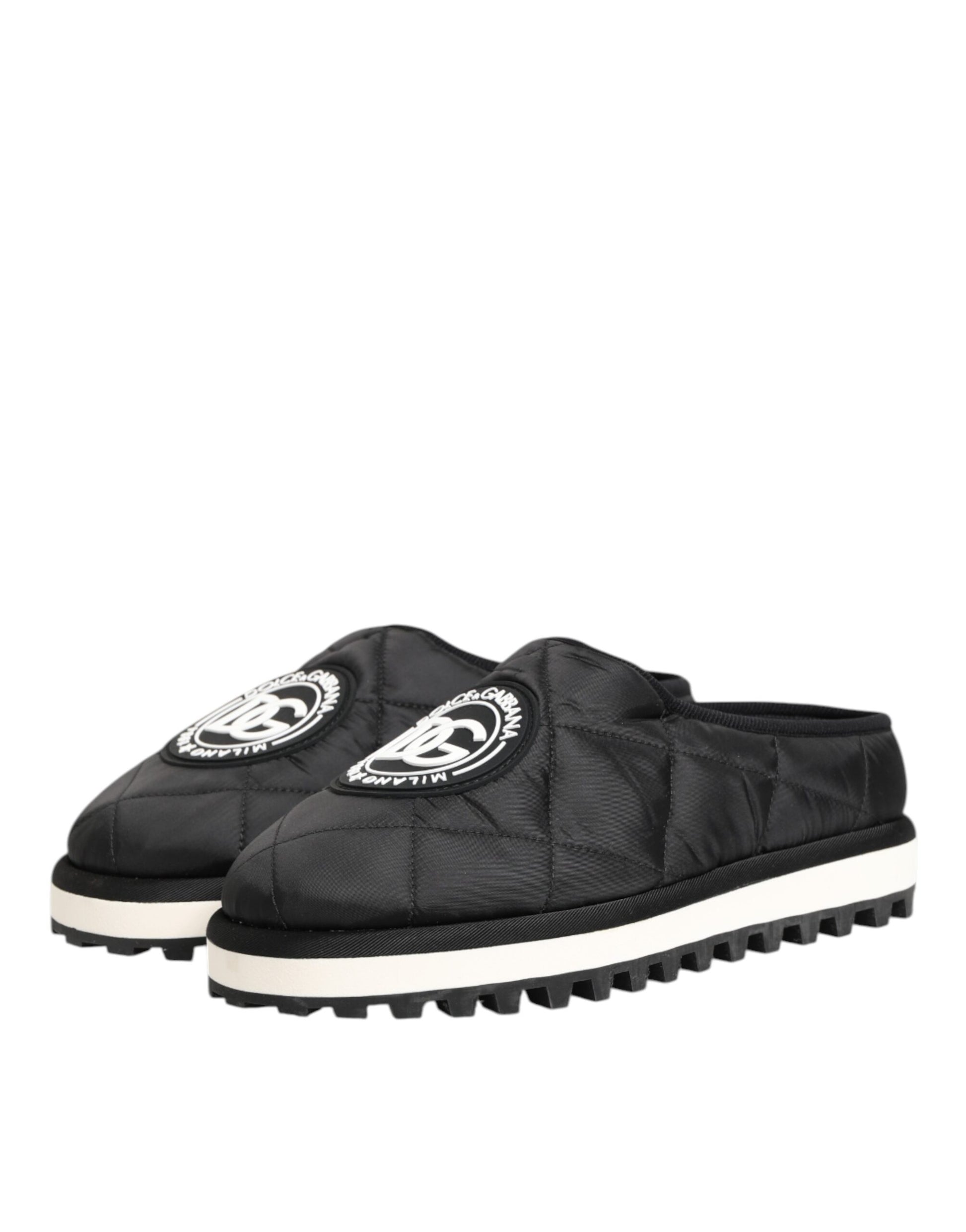 A pair of black nylon slip-on shoes with white soles and a logo on the side