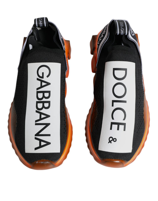 Pair of black and orange sneakers with white brand names on side