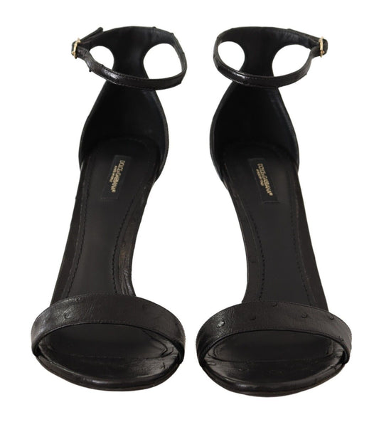 Pair of black high heel shoes with ankle straps and a bow on top
