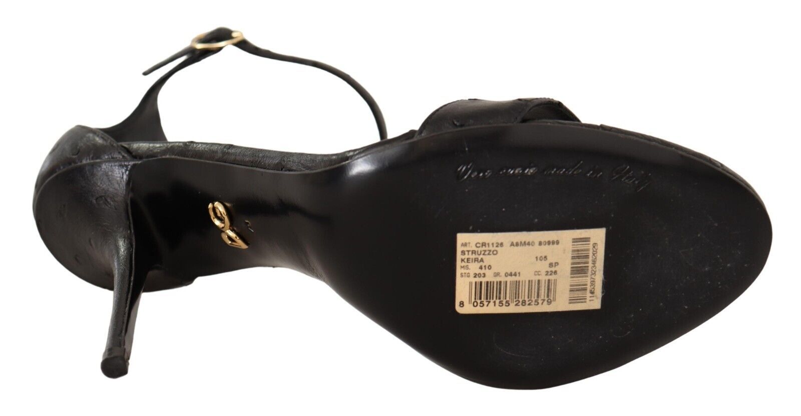 Black high heel shoe with gold accents and tag attached to sole
