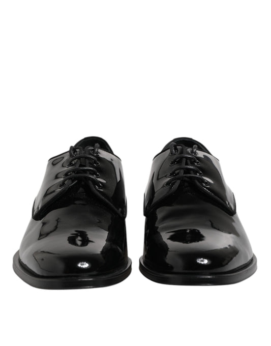 Pair of black patent leather dress shoes with laces and a small round emblem on the side