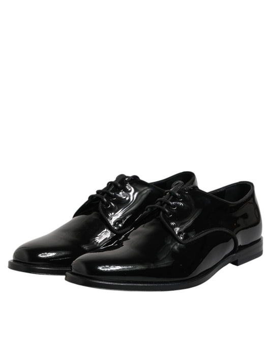 Pair of black patent leather dress shoes with laces and a bow tie design