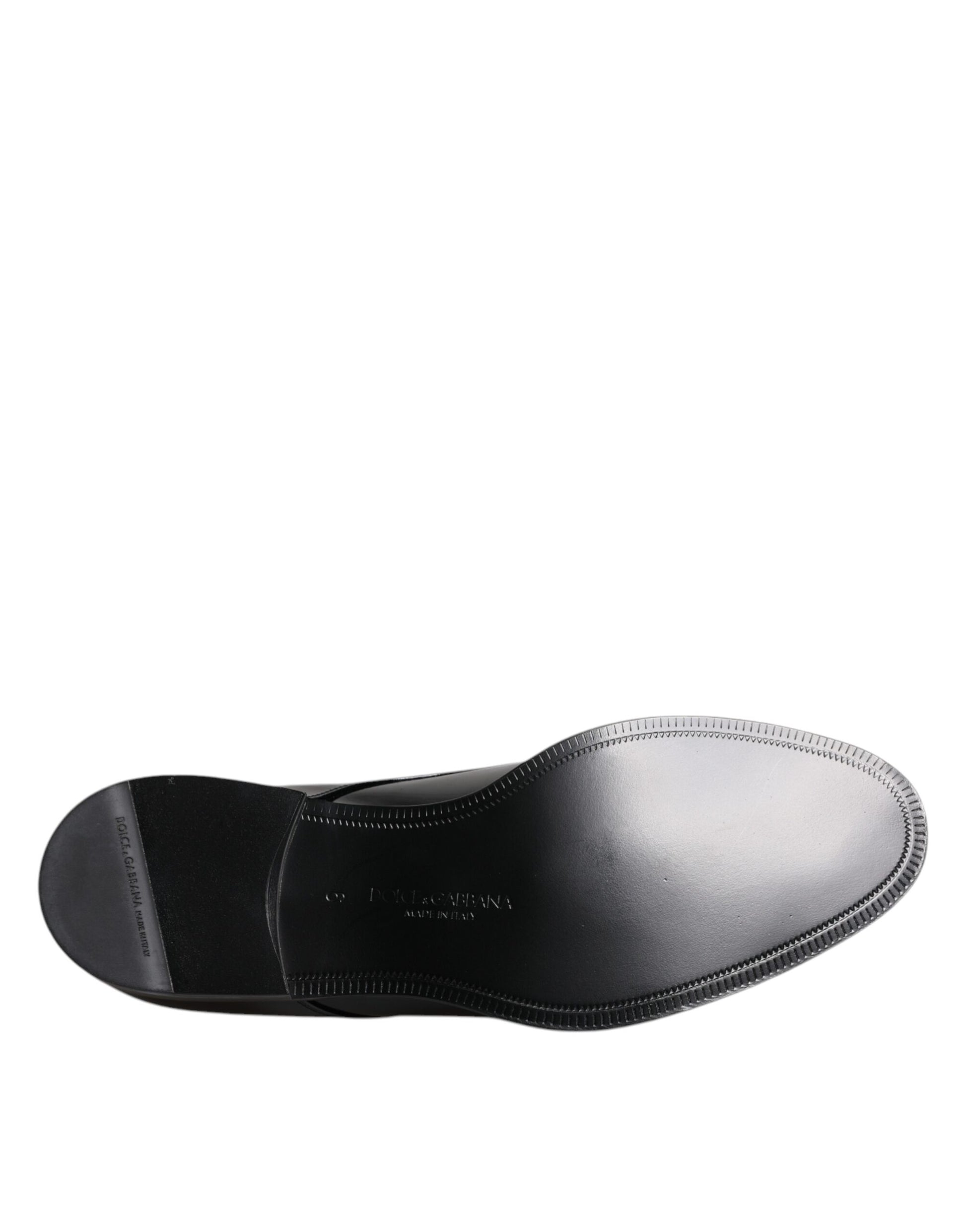 A single black patent leather dress shoe with a lace-up front and a small heel