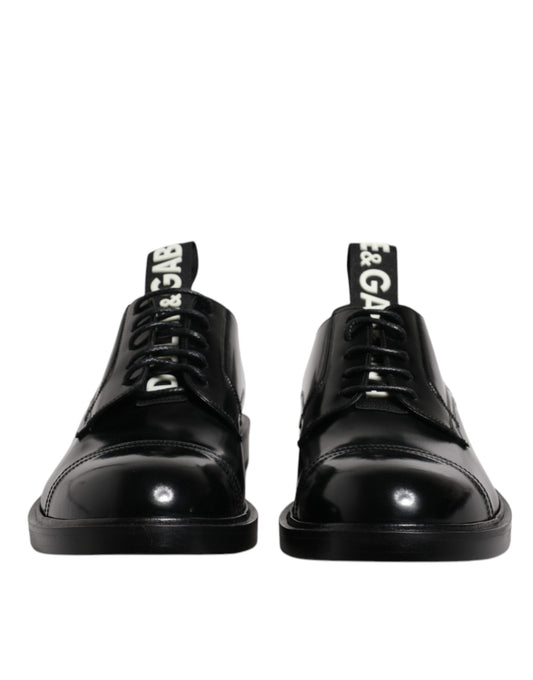 Pair of black patent leather dress shoes with laces, featuring a shiny finish and a brand logo on the side