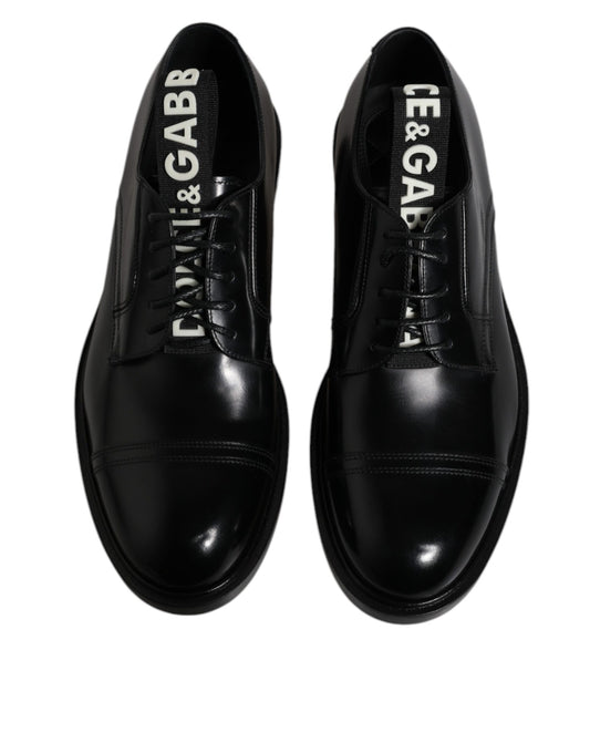 Pair of black patent leather dress shoes with laces, featuring the brand name "Dolce & Gabbana" on side