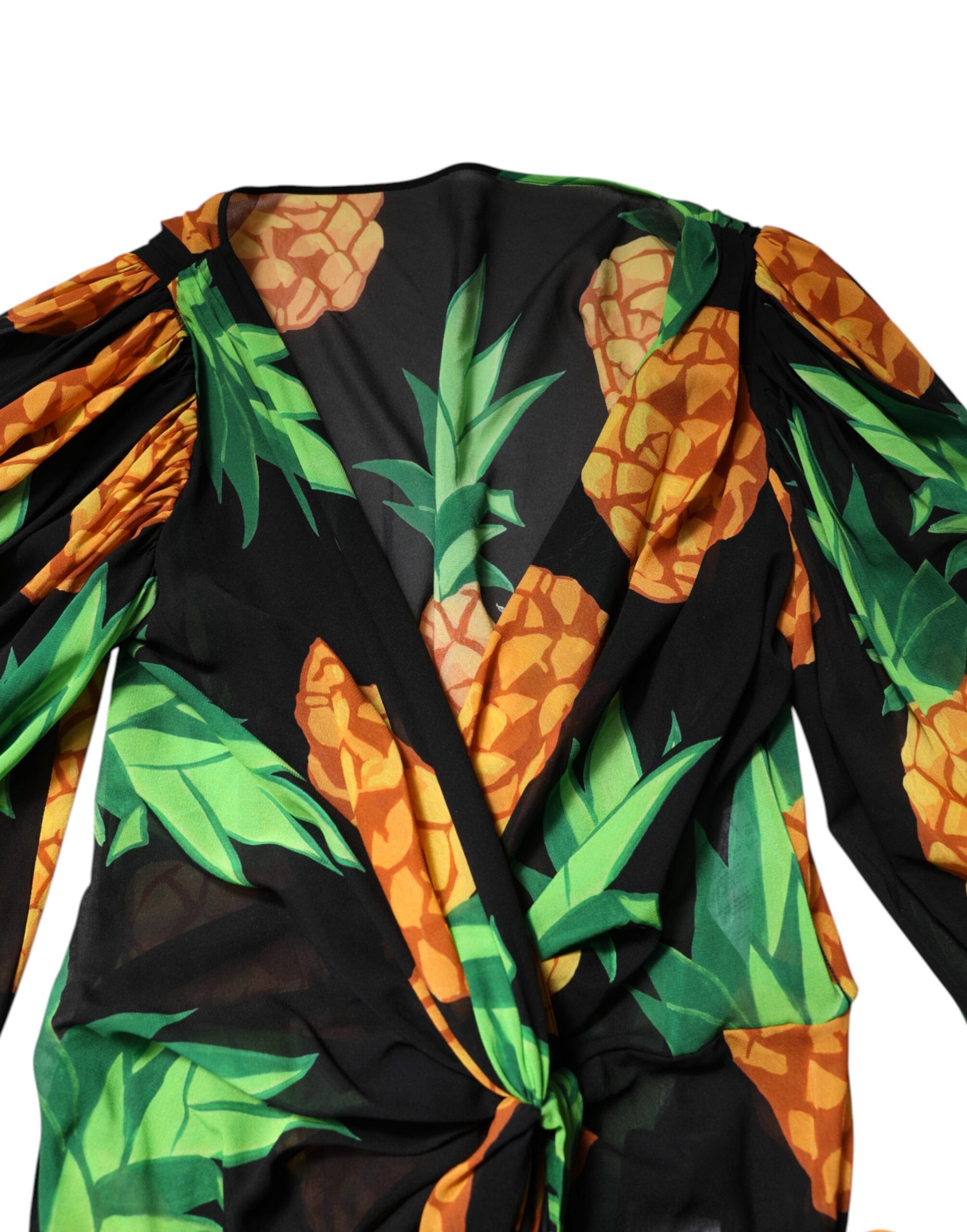 A black pineapple print silk wrap mini dress with a vibrant tropical design