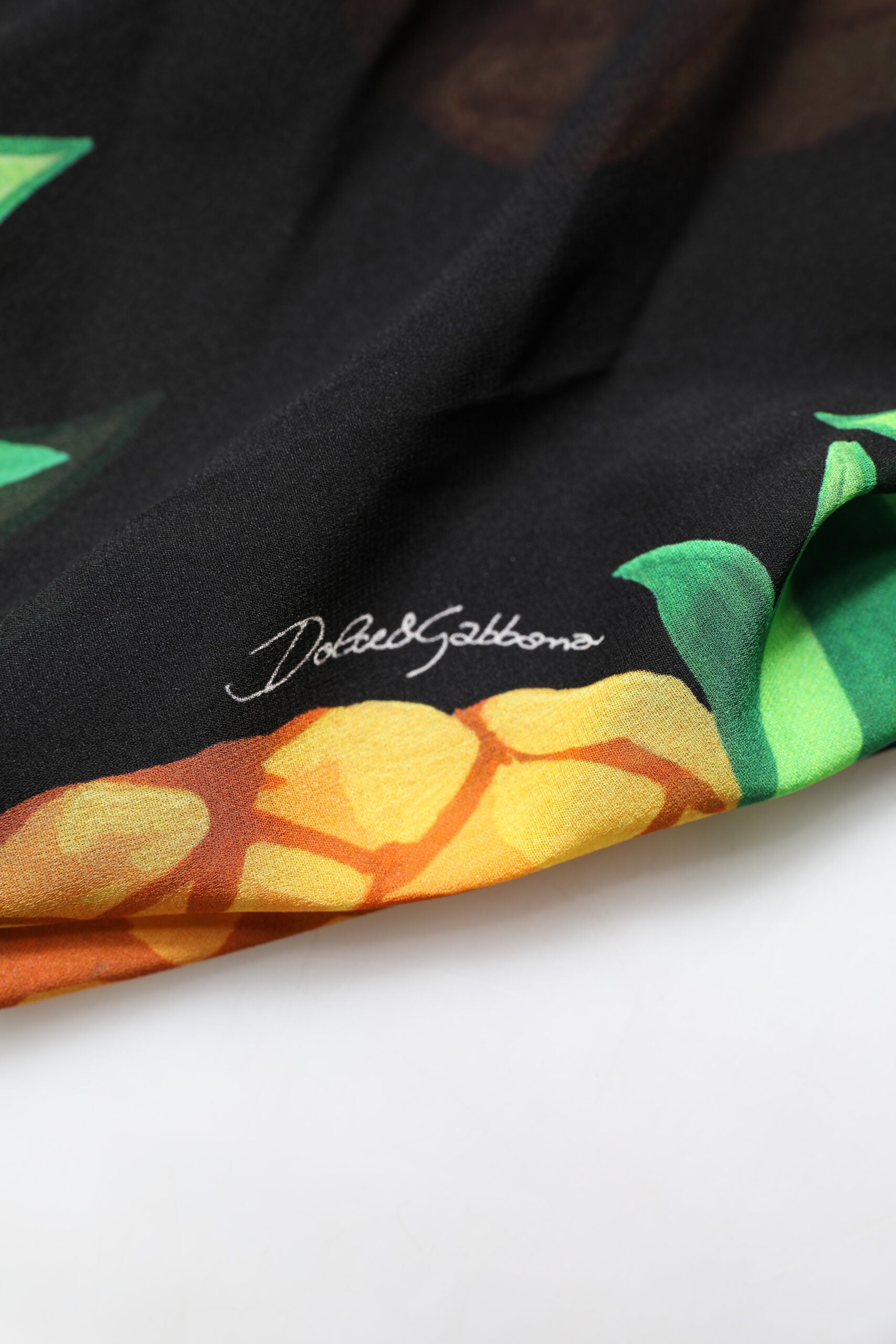 A black pineapple print silk wrap mini dress by Dolce & Gabbana