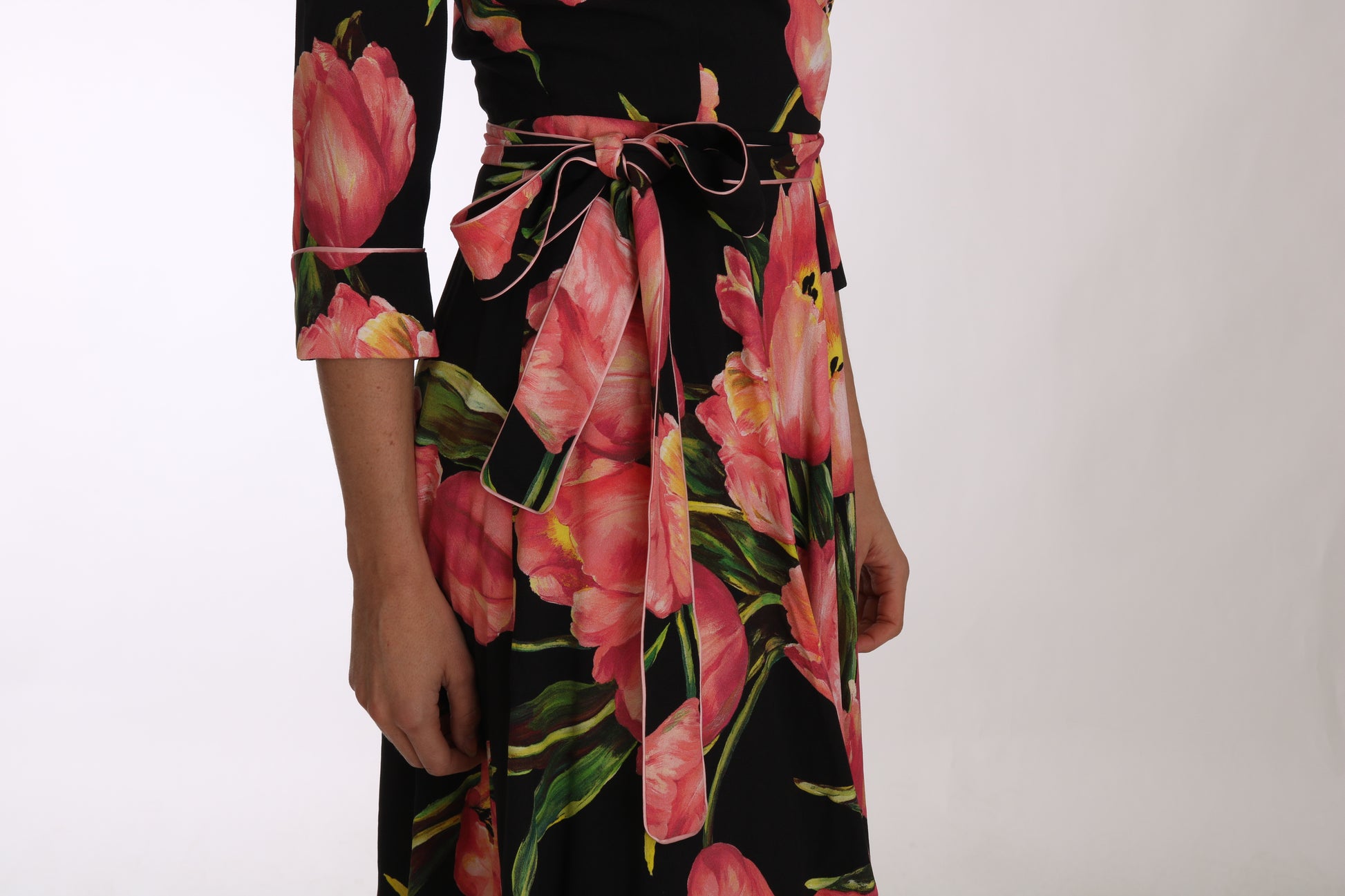 A black dress with a pink tulip print and belt detailing