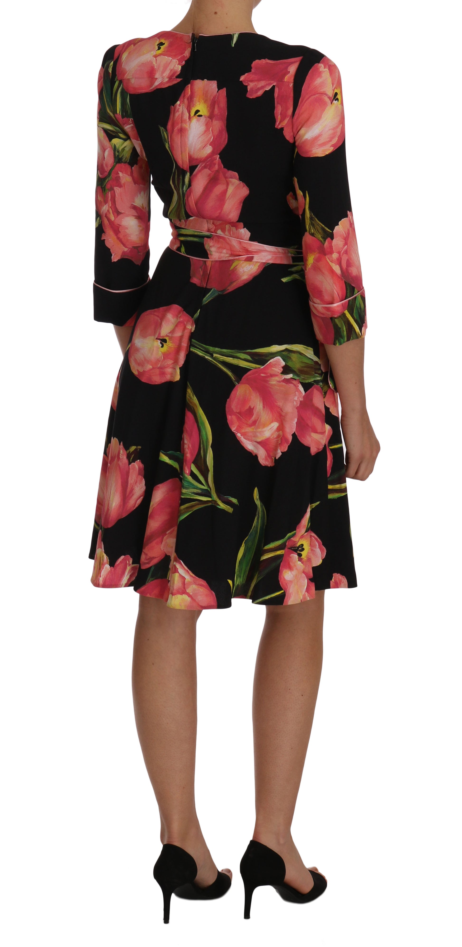 A black dress with a floral print featuring pink tulips and green leaves