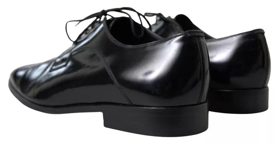 Pair of black polished leather formal dress shoes with laces and a shiny finish
