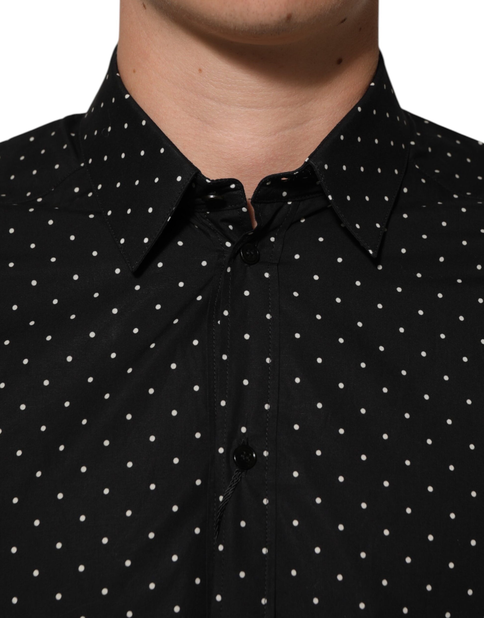 A black polka dot shirt with a collar and buttons on the front