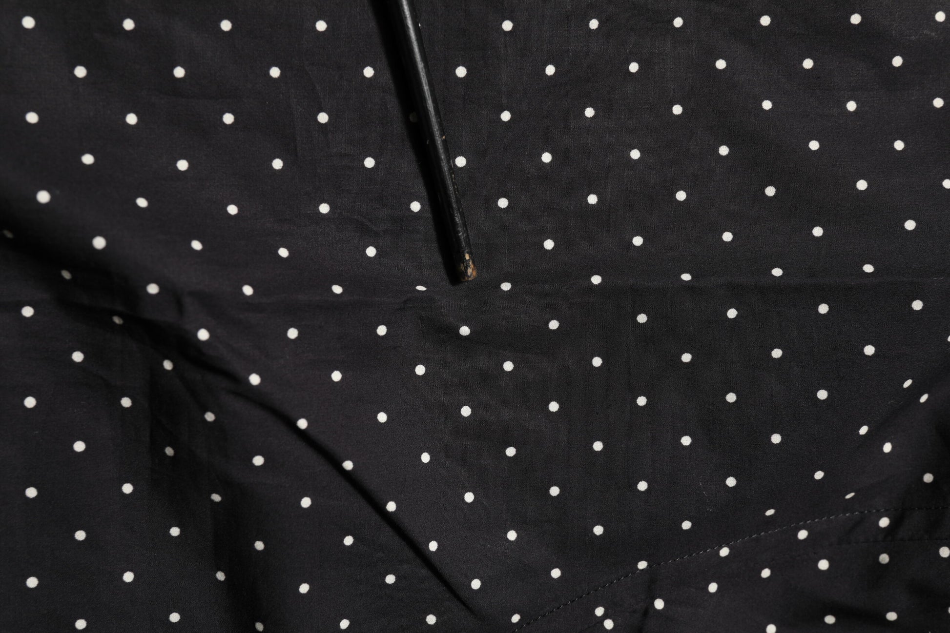 A black polka dot dress shirt with gold accents, designed for men's formal wear