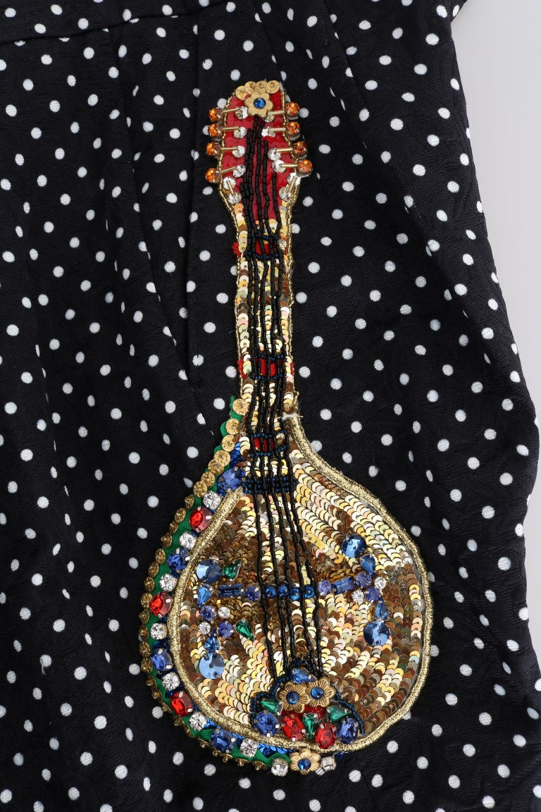 Decorative embroidered musical instrument on a black and white polka dot fabric