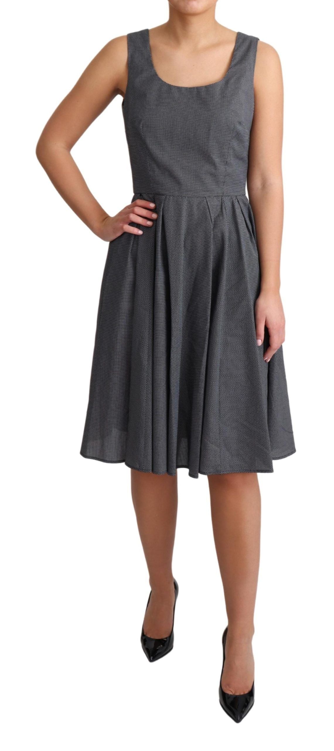 A black polka dotted cotton dress with a flared skirt and short sleeves
