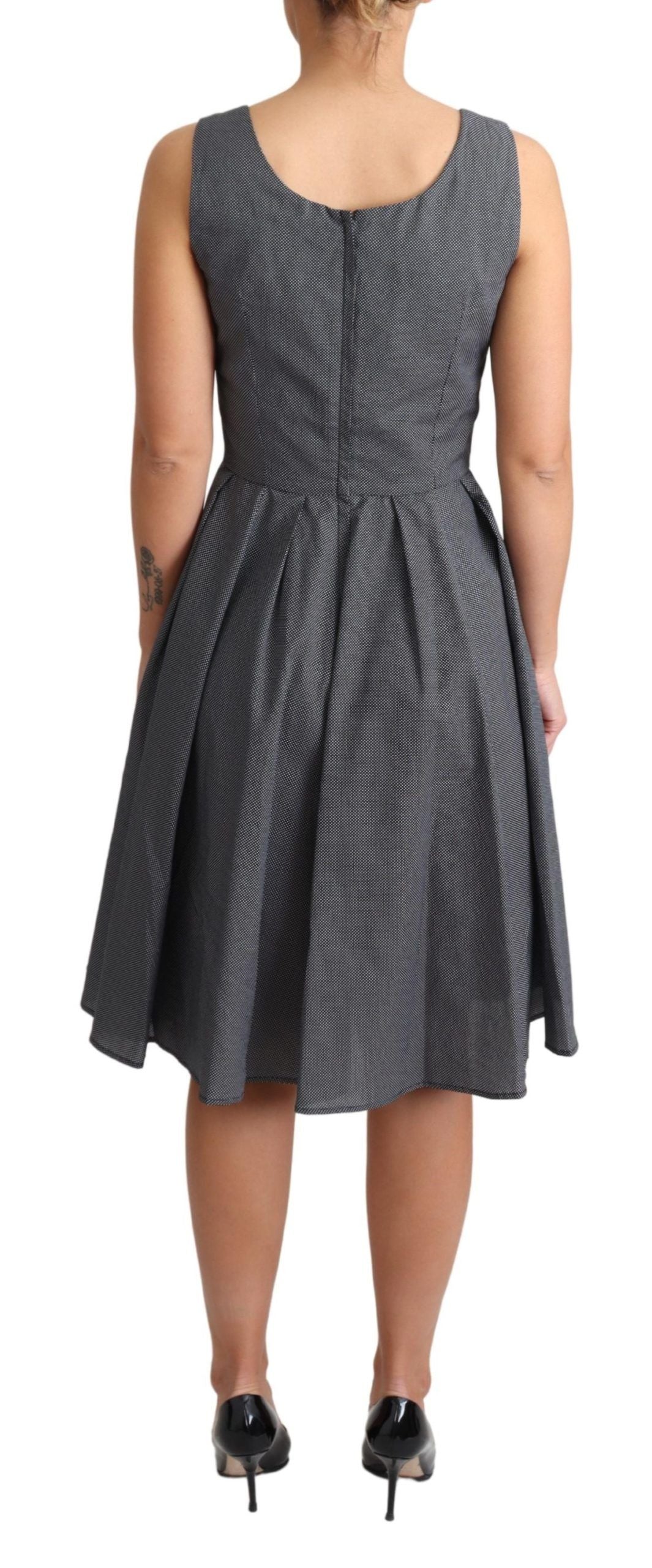 A black polka dotted cotton dress with a flared skirt and fitted bodice