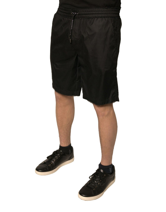 A pair of black polyester jersey mid waist shorts