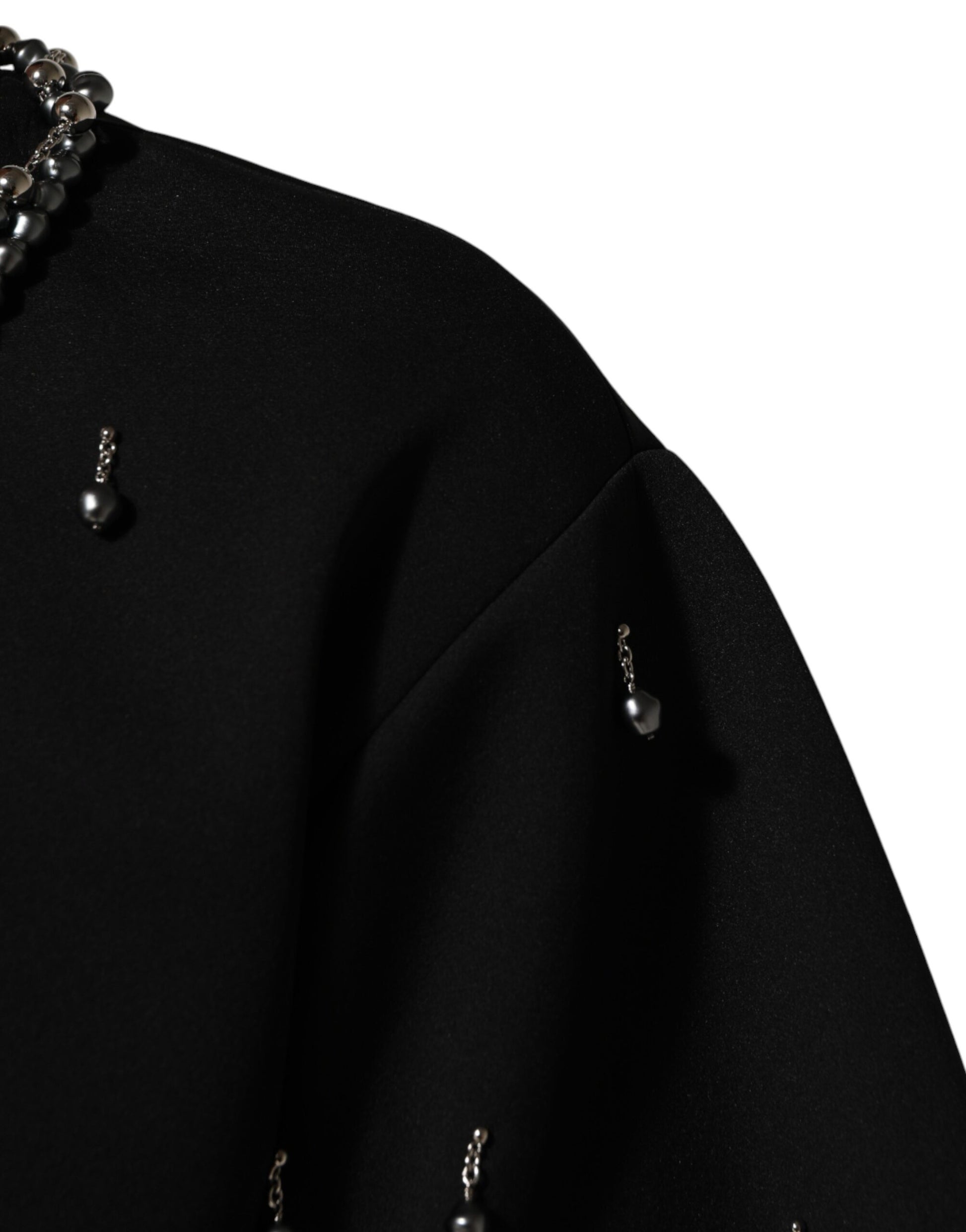 Black garment with pearl embellishments on sleeve