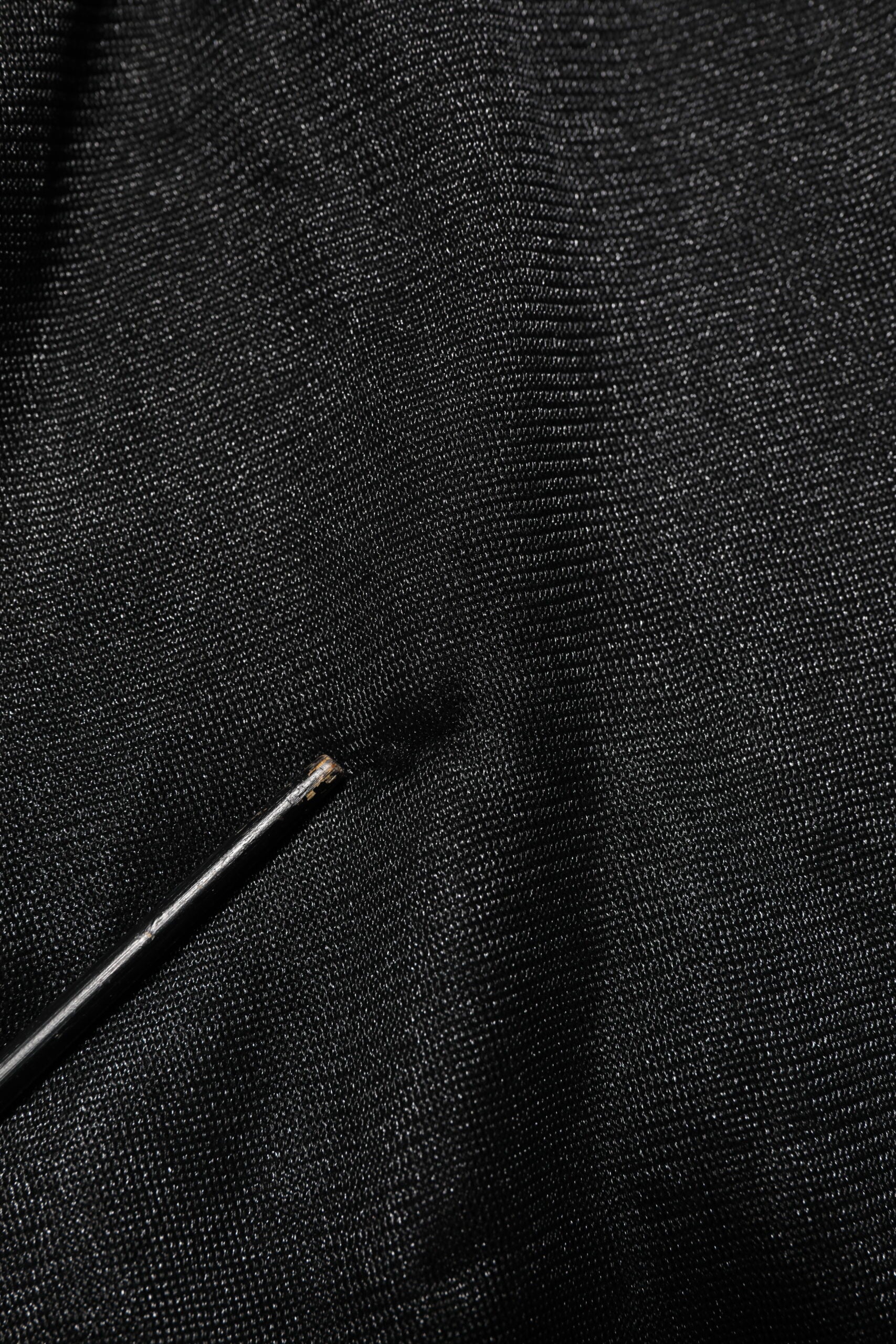 Black fabric with a small black wire or thread running through it