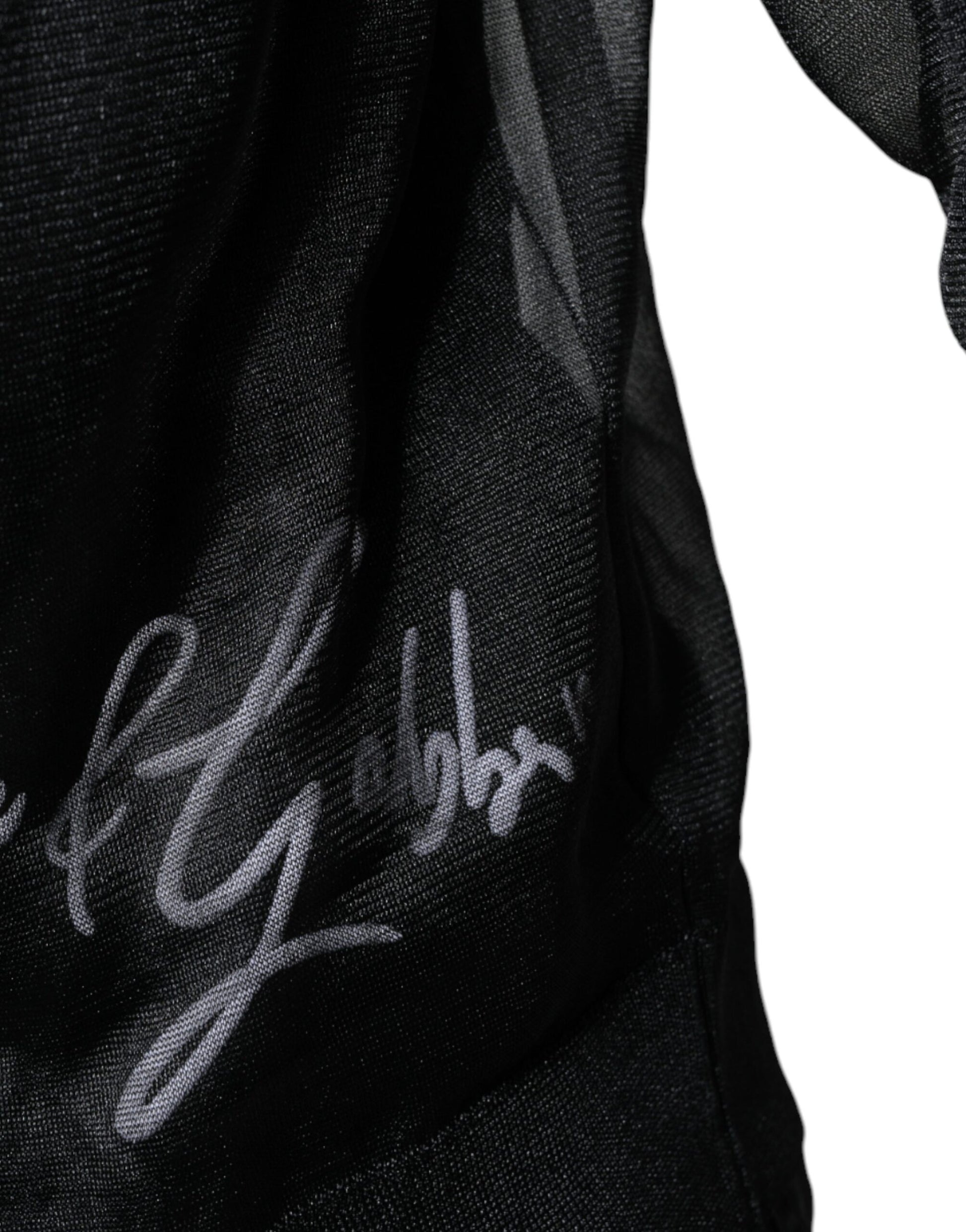 Black cloth item with white signature on it